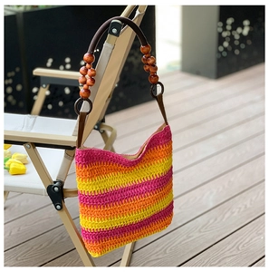 Detail of rainbow straw bucket bag with brown rope handle and wooden bead accents