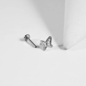 Vue macro d'un piercing labret papillon argenté avec zircons blancs et tige filetée