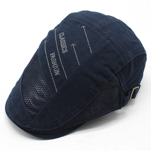 Detail view of navy blue beret with mesh panels and white letter embroidery