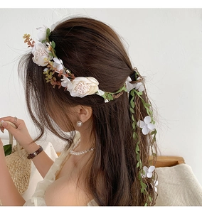Detailed back view of white floral wreath headband with long cascading ribbon accents