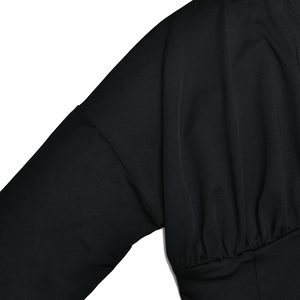 Detailed view of the shoulder and sleeve on this black woven fabric tracksuit set