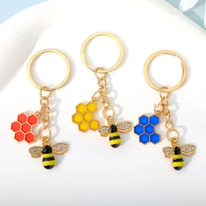 Golden bee keychains with honeycomb charms in red, yellow and blue enamel finish