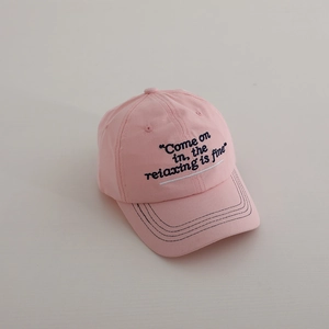 Detail of light pink cotton baseball cap with black cursive embroidery and stitching