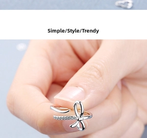 Close-up of a silver bow ring with shimmering white zircon stones and adjustable band