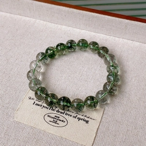Macro detail of natural green phantom quartz beads with unique mineral inclusions