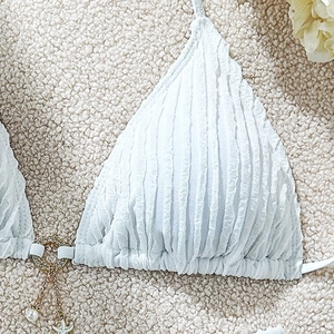 Detail of light blue textured bikini with gold starfish and pearl charms on metal ring