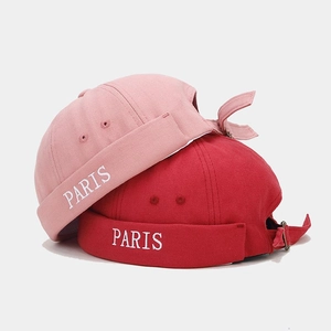 Detail of pink and red cotton docker hats featuring white PARIS embroidery on the side