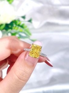 Macro shot of Radiant cut yellow gemstone ring with micropavé diamonds on silver band
