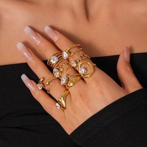 Macro view of gold-tone irregular stacked rings featuring zircon stones and molten texture