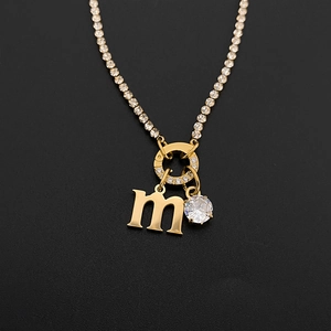 Close-up of 14K gold plated titanium steel necklace with letter M and crystal charms