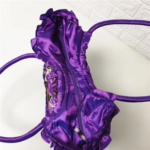 Top view detail of purple satin handbag showing zipper closure and ruffled edges