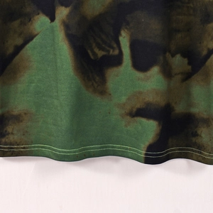 Vue macro de l'ourlet à double couture sur robe en maille tie-dye vert et noir