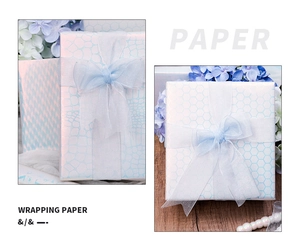 Macro detail of light blue honeycomb textured wrapping paper with elegant ribbon