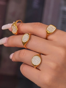 Vier goldene Ringe mit Pavé-Zirkonia in geometrischen Herzformen in der Nahaufnahme