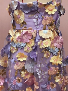 Détail de la broderie florale 3D et du zip invisible au dos d'une robe en tulle violet