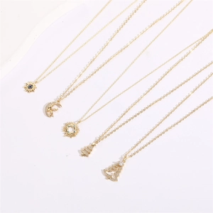 Detail view of 14K gold plated necklaces with sun moon and Christmas tree zircon pendants