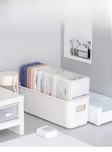 White frosted plastic organizer box with handles, storing colorful phone cases on a desk