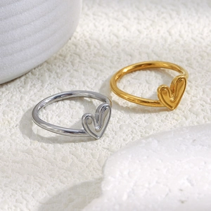 Vue détaillée des bagues cœur plaquées or 18 carats et argent sur pierre blanche texturée
