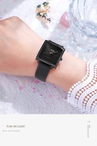 Close-up of a women's vintage square black dial quartz watch with leather strap on wrist