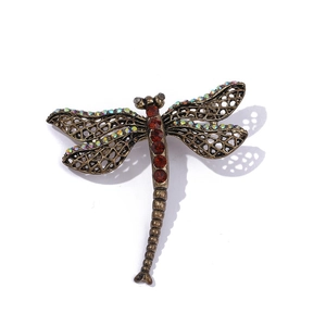 Macro detail of dragonfly brooch wings with bronze finish and red rhinestone inlay