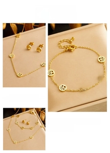 Detail view of gold Tree of Life jewelry set including necklace, bracelet, and stud earrings
