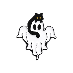 Detail of a Halloween enamel pin featuring a white ghost and a black cat with yellow eyes