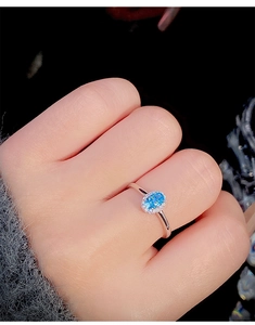 Close-up of S925 sterling silver ring featuring oval blue gemstone and diamond halo