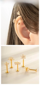 Macro display of titanium gold labret studs with flower and butterfly zirconia designs