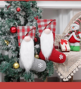 Close-up of gray and red gnome Christmas stockings hanging on a festive holiday tree