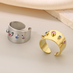 Detailed view of gold and silver irregular wave rings with multi-color zircon stones