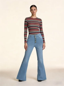 Detail of high waisted flare jeans with multi-button closure and light blue wash