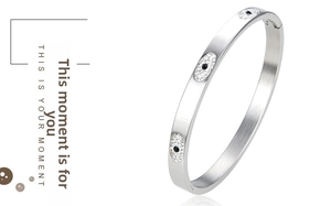 Close-up of silver steel open bangle with evil eye design and sparkling crystals