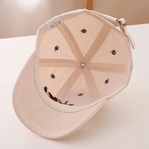 Detail view of cotton inner lining and stitching of the beige children baseball cap