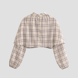 Detail of the back view of a plaid cropped blouse featuring a white button closure