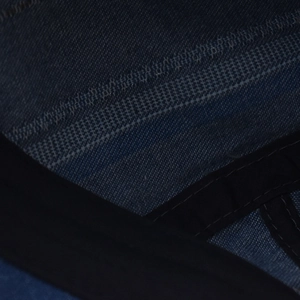 Macro shot of denim beret interior stitching and high-quality dark blue fabric texture