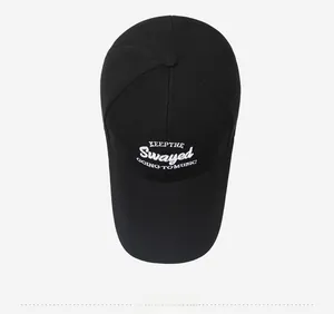 Overhead view of black cotton baseball cap with white 3D embroidery detail