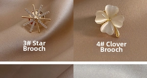 Détail de broches trèfle et étoile dorées sur un tissu en satin de couleur champagne