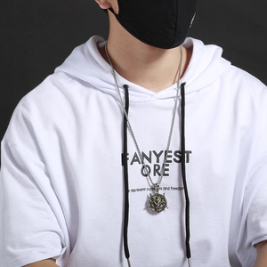 Nahaufnahme eines silber-goldenen Punk-Tierkopf-Anhängers mit Flügeln an einer Stahlhalskette