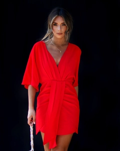 Détail de la robe rouge à décolleté en V profond avec plis à la taille et coupe slim