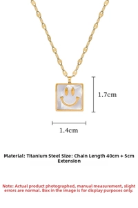 Detail of 18k gold plated titanium square smiley face pendant with pearl inlay