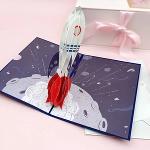 Detail of 3D pop-up birthday card featuring a rocket launching from the moon surface