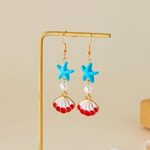 Detailed close-up of ocean-themed earrings featuring blue starfish and shell pendants