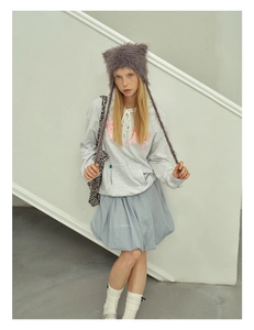 Detail of furry gray cat ear hat with long tassels paired with casual winter outfit