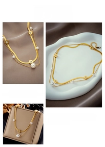 Dettaglio della collana a doppio strato in oro con perle e pendente a numeri romani
