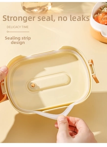 Detail of food-grade silicone sealing ring and orange air vent on creamy yellow lunch box lid