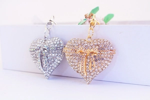 Detailed view of silver and gold heart keychains with rhinestones and butterfly bows