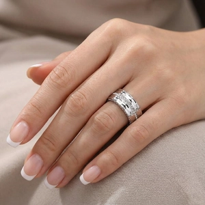 Close-up of a wide silver titanium ring with hammered texture and pave diamonds on hand