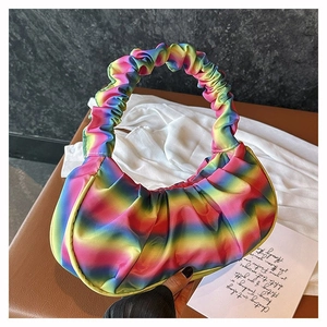 Detail of colorful rainbow gradient pleated shoulder bag with soft satin texture
