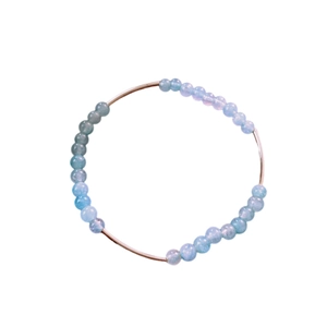 Elegant aquamarine beaded bracelet with silver curved metal bars on a clean white background