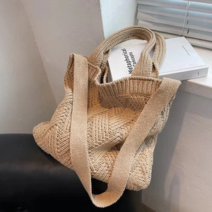 Detail shot of beige knitted tote bag with diamond pattern texture on leather seat